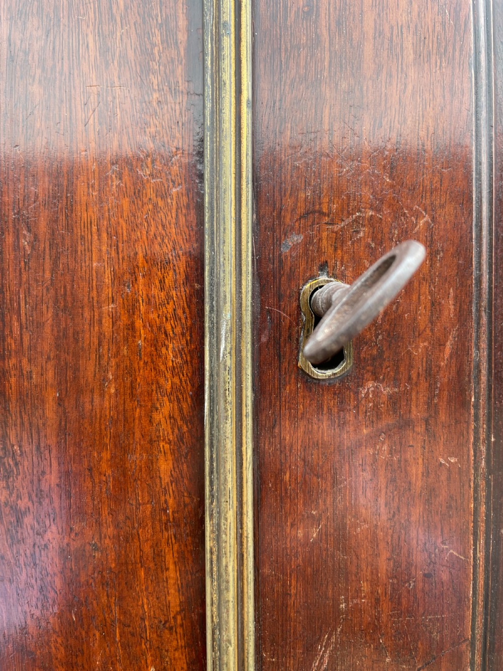 A late eighteenth-century George III mahogany estate cabinet featuring upper panel doors above drawers with gilded alphabetical lettering. View XXX