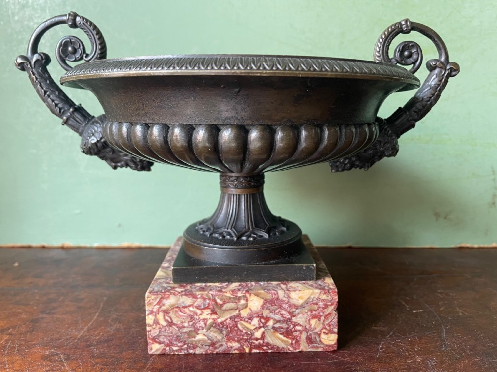 A pair of 19th-century dark bronze tazzas featuring gadrooned bowls and scroll handles, each mounted on a square red mottled marble base. View IV