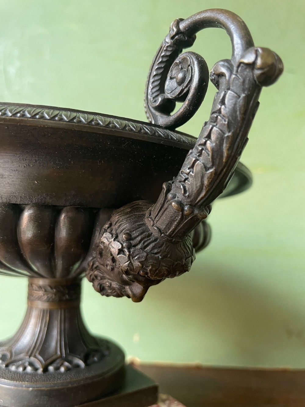 A pair of 19th-century dark bronze tazzas featuring gadrooned bowls and scroll handles, each mounted on a square red mottled marble base. View VI