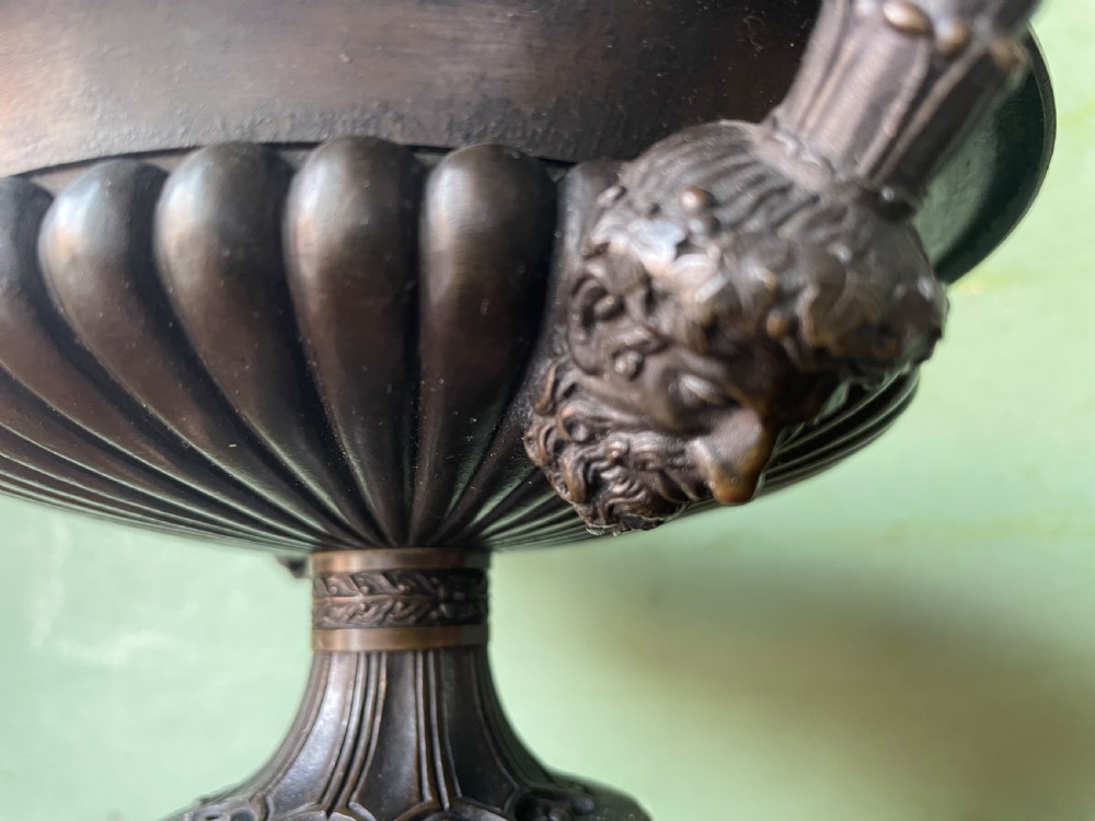 A pair of 19th-century dark bronze tazzas featuring gadrooned bowls and scroll handles, each mounted on a square red mottled marble base. View VII