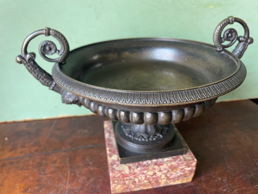 A pair of 19th-century dark bronze tazzas featuring gadrooned bowls and scroll handles, each mounted on a square red mottled marble base. View XII