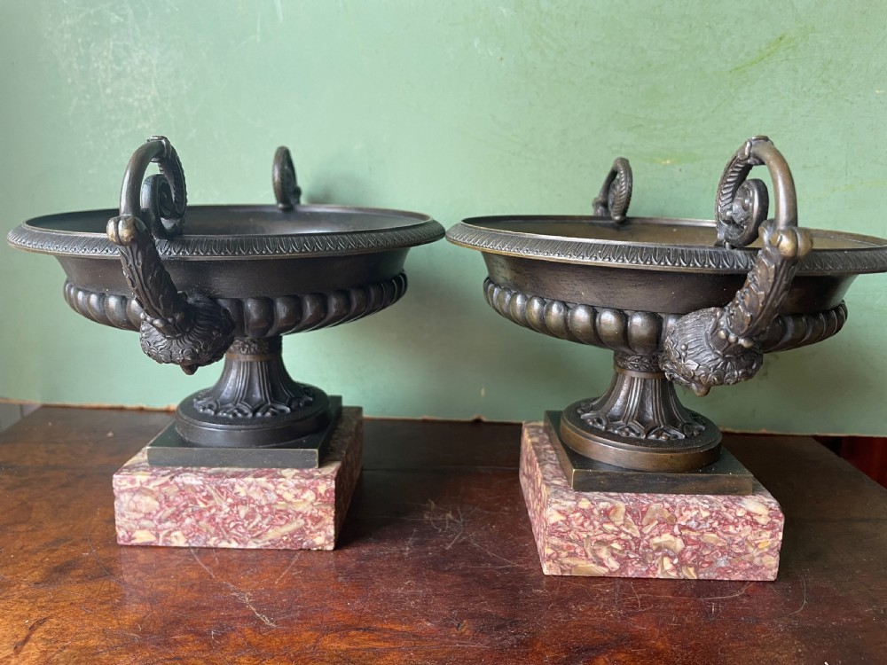 A pair of 19th-century dark bronze tazzas featuring gadrooned bowls and scroll handles, each mounted on a square red mottled marble base. View XVII