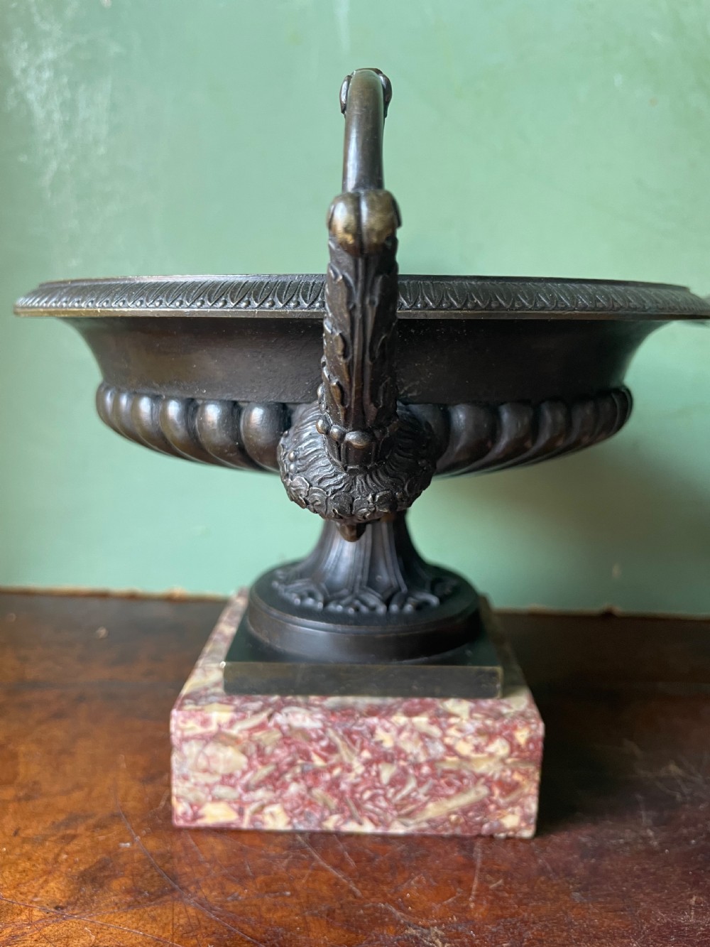 A pair of 19th-century dark bronze tazzas featuring gadrooned bowls and scroll handles, each mounted on a square red mottled marble base. View XVIII