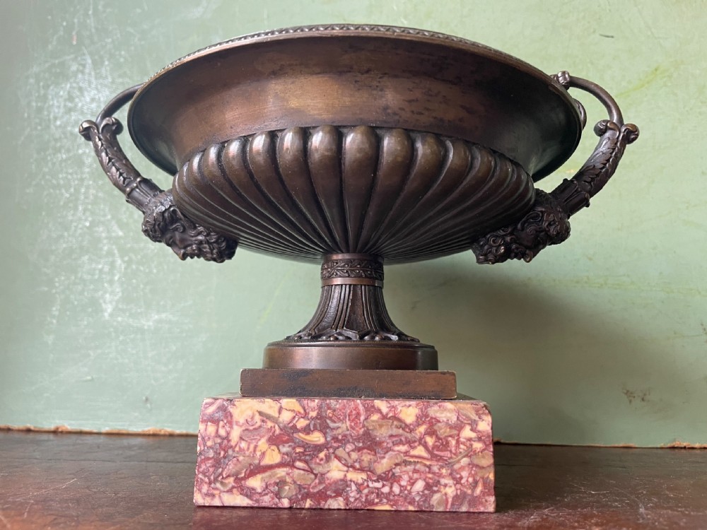 A pair of 19th-century dark bronze tazzas featuring gadrooned bowls and scroll handles, each mounted on a square red mottled marble base. View XXI
