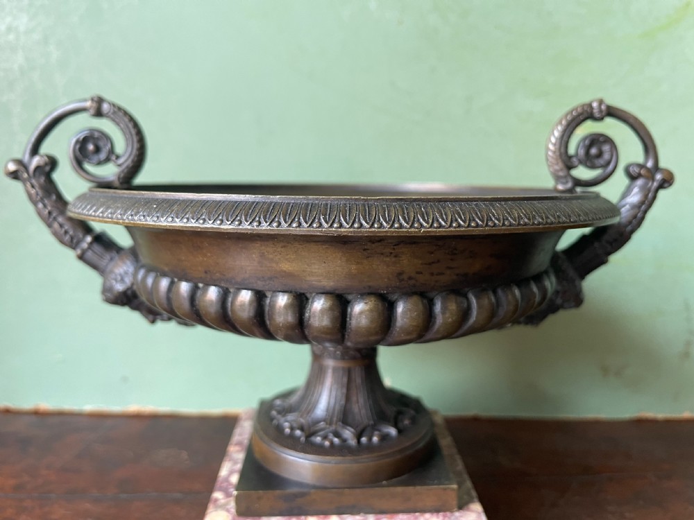 A pair of 19th-century dark bronze tazzas featuring gadrooned bowls and scroll handles, each mounted on a square red mottled marble base. View XXII