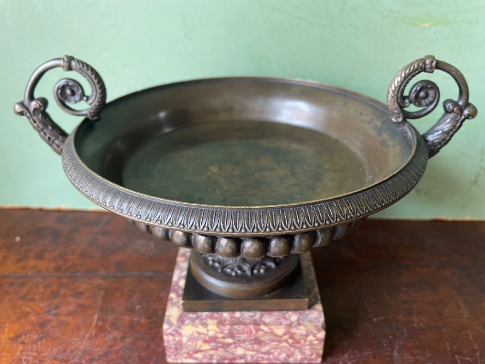 A pair of 19th-century dark bronze tazzas featuring gadrooned bowls and scroll handles, each mounted on a square red mottled marble base. View XXIII