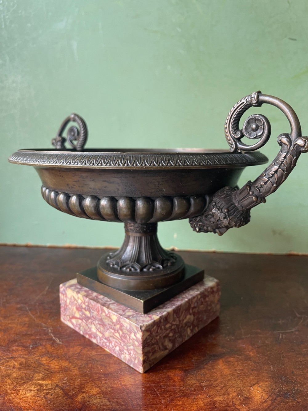 A pair of 19th-century dark bronze tazzas featuring gadrooned bowls and scroll handles, each mounted on a square red mottled marble base. View XXV