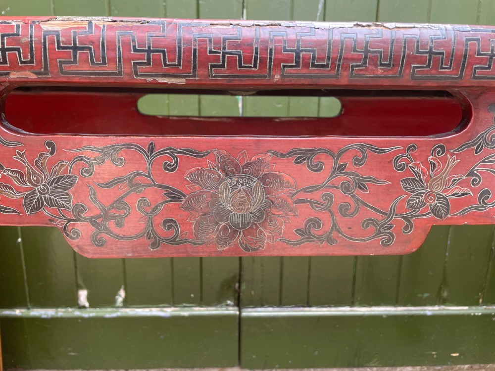 A late nineteenth-century Chinese red lacquered altar table featuring carved decorative spandrels and a patinated surface. View VI