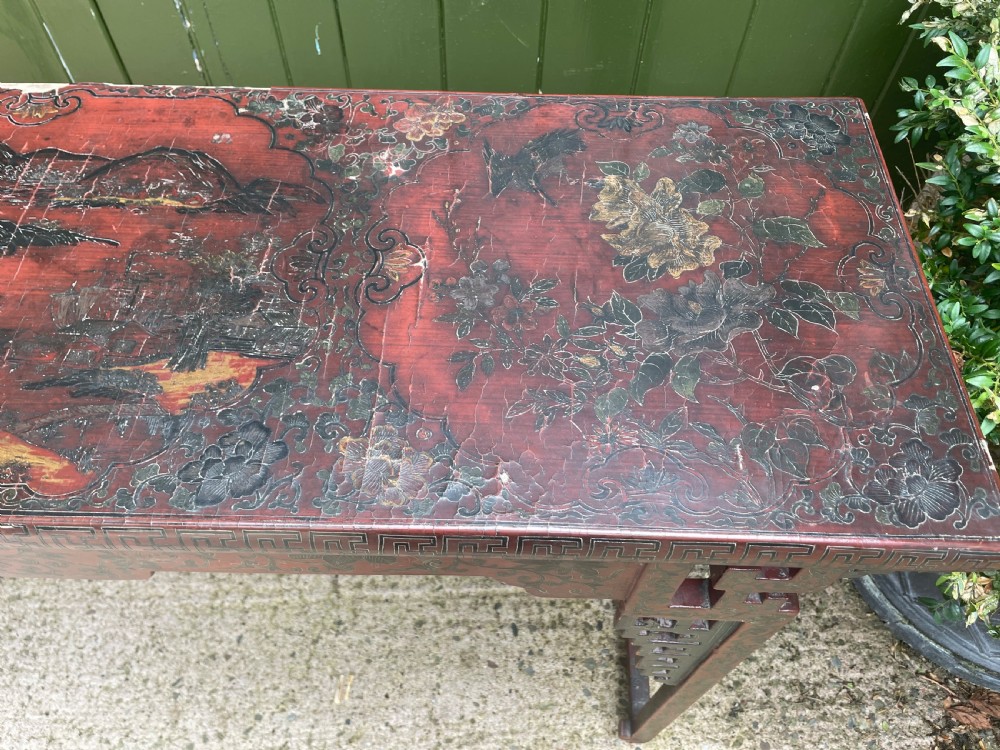 A late nineteenth-century Chinese red lacquered altar table featuring carved decorative spandrels and a patinated surface. View IX