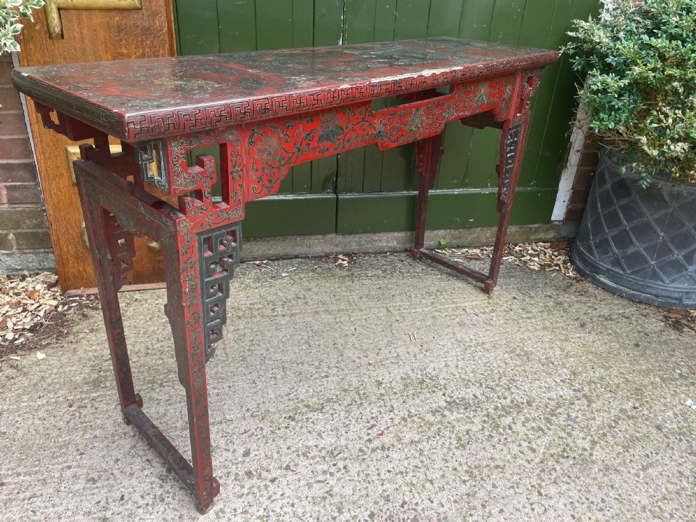 A late nineteenth-century Chinese red lacquered altar table featuring carved decorative spandrels and a patinated surface. View XII