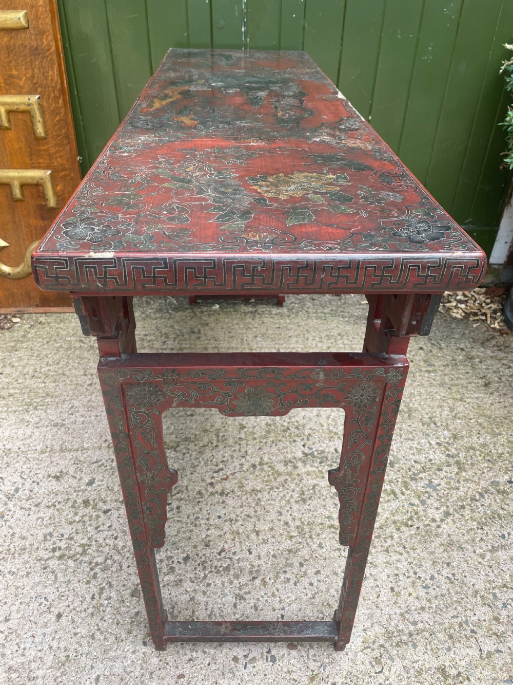 A late nineteenth-century Chinese red lacquered altar table featuring carved decorative spandrels and a patinated surface. View XIV