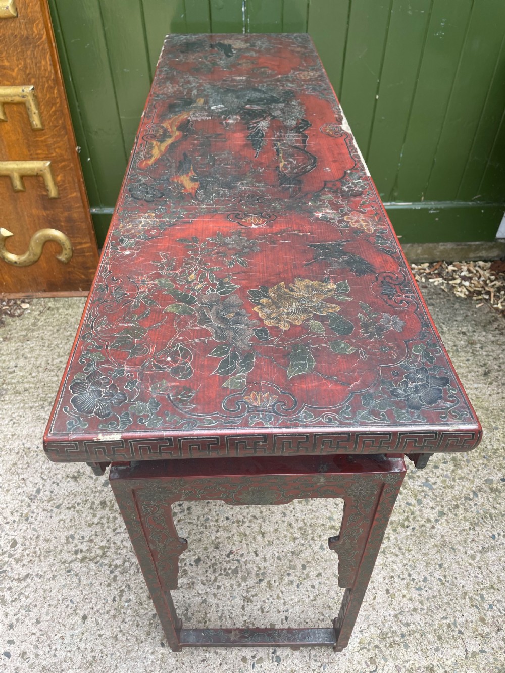 A late nineteenth-century Chinese red lacquered altar table featuring carved decorative spandrels and a patinated surface. View XV