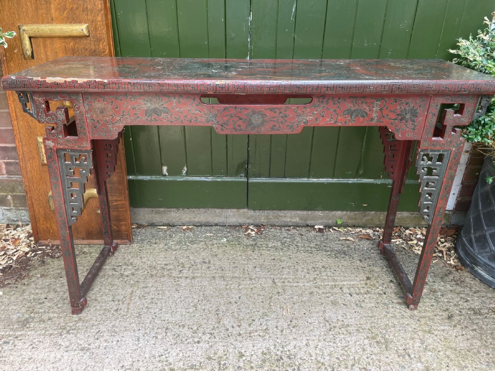 A late nineteenth-century Chinese red lacquered altar table featuring carved decorative spandrels and a patinated surface. View XVII