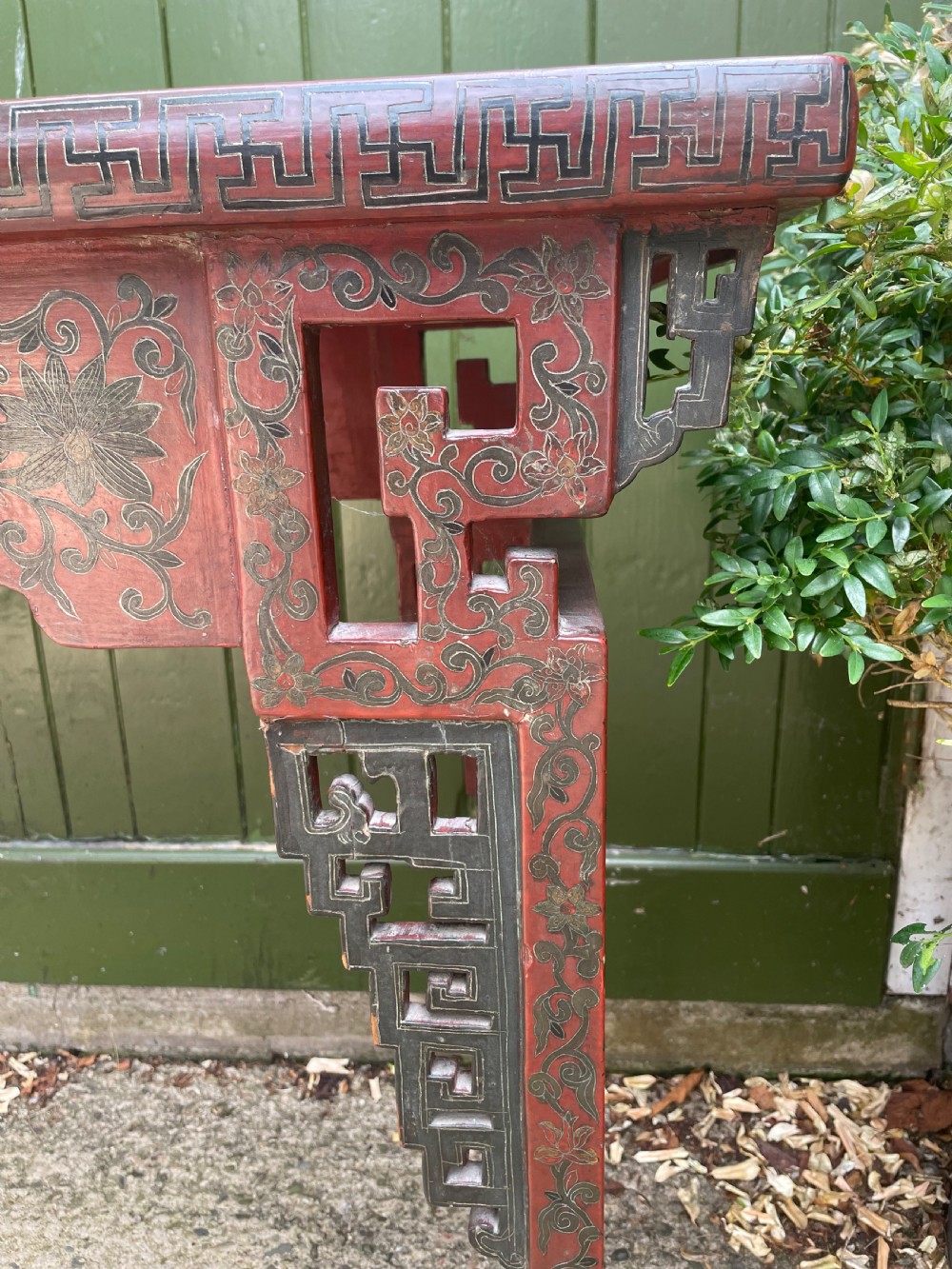 A late nineteenth-century Chinese red lacquered altar table featuring carved decorative spandrels and a patinated surface. View XVIII