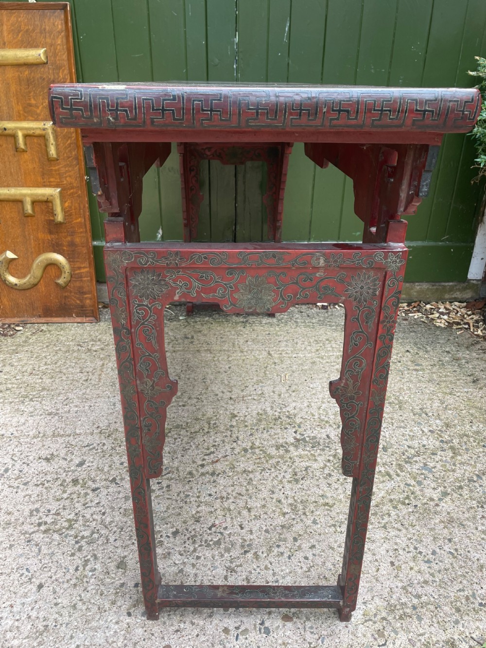 A late nineteenth-century Chinese red lacquered altar table featuring carved decorative spandrels and a patinated surface. View XIX