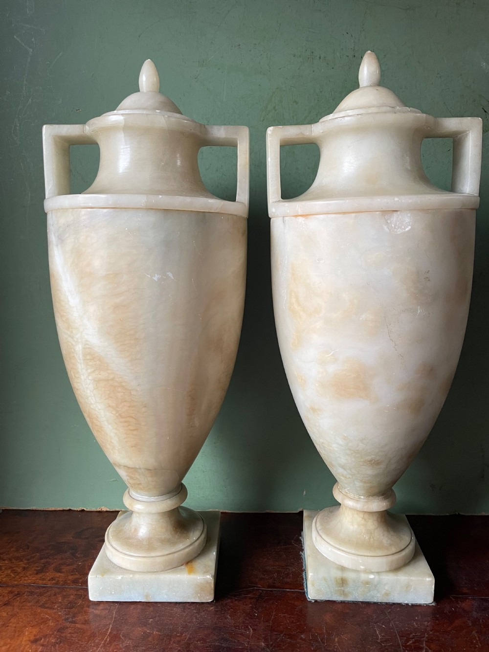 A pair of early nineteenth-century carved cream alabaster classical urns with lids, angular side handles, and square pedestal bases. View II