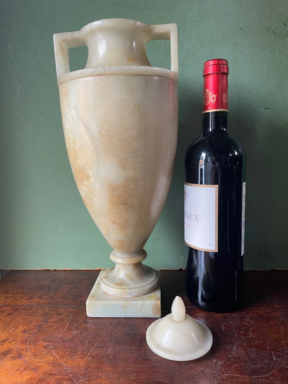 A pair of early nineteenth-century carved cream alabaster classical urns with lids, angular side handles, and square pedestal bases. View XIX