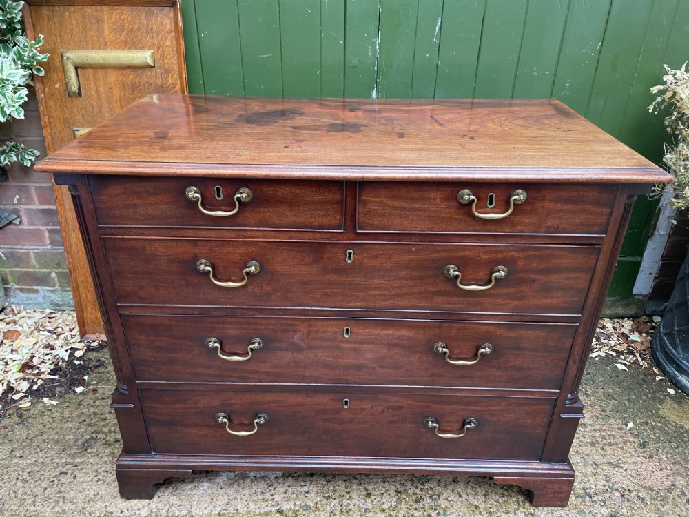 A mid-18th century George III mahogany chest of drawers featuring a two over three drawer layout with brass handles and bracket feet. View II