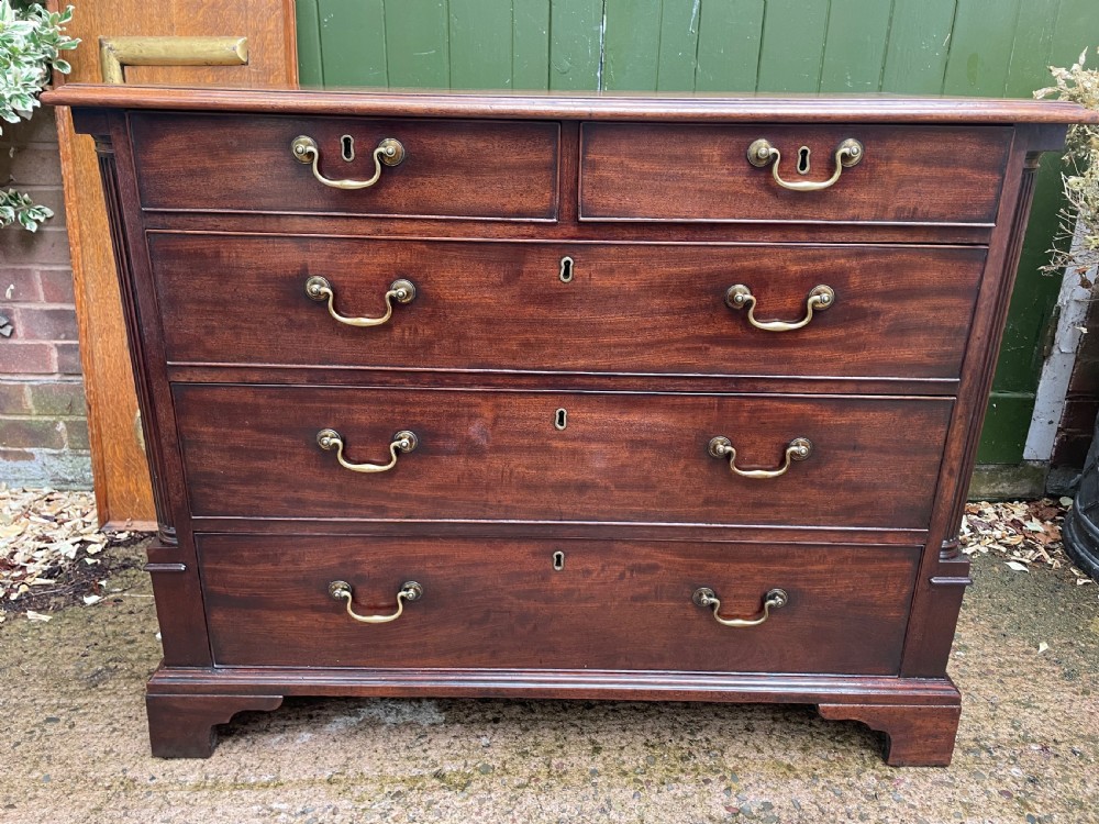 A mid-18th century George III mahogany chest of drawers featuring a two over three drawer layout with brass handles and bracket feet. View III