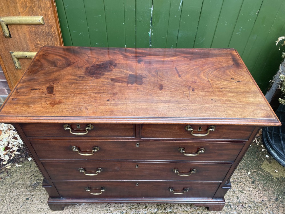 A mid-18th century George III mahogany chest of drawers featuring a two over three drawer layout with brass handles and bracket feet. View V