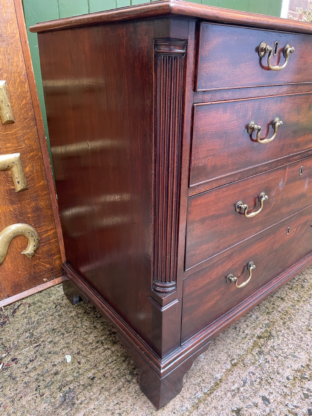A mid-18th century George III mahogany chest of drawers featuring a two over three drawer layout with brass handles and bracket feet. View VII