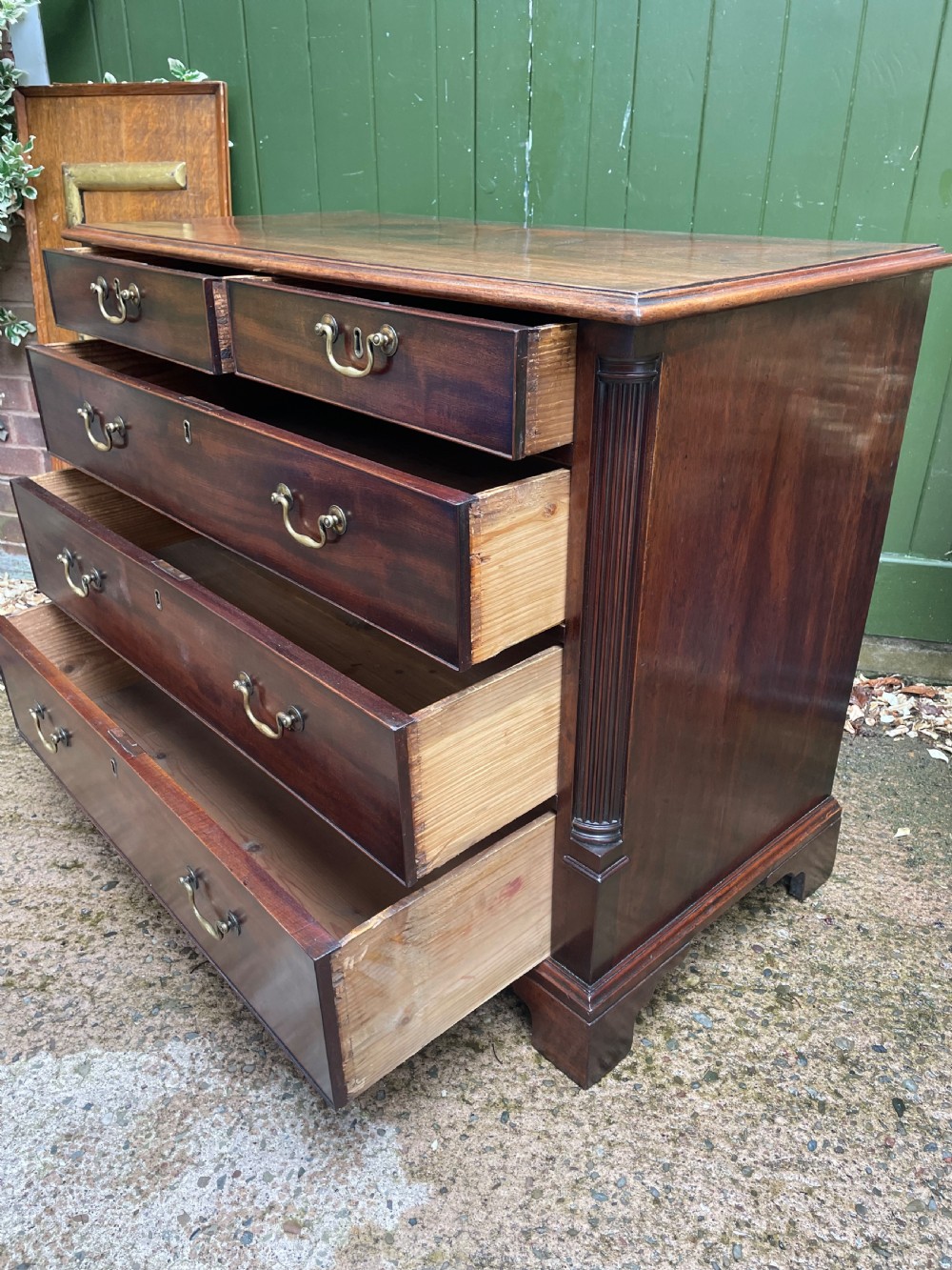 A mid-18th century George III mahogany chest of drawers featuring a two over three drawer layout with brass handles and bracket feet. View X