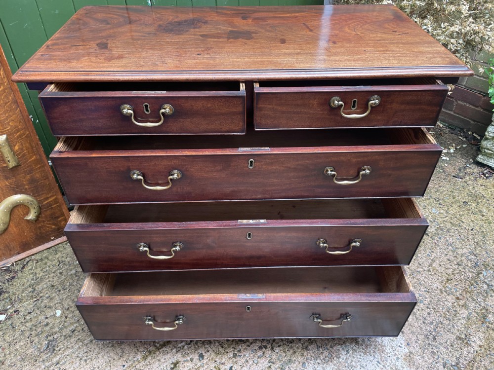 A mid-18th century George III mahogany chest of drawers featuring a two over three drawer layout with brass handles and bracket feet. View XI