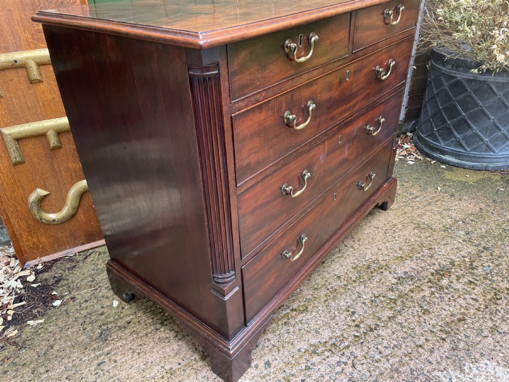 A mid-18th century George III mahogany chest of drawers featuring a two over three drawer layout with brass handles and bracket feet. View XIII