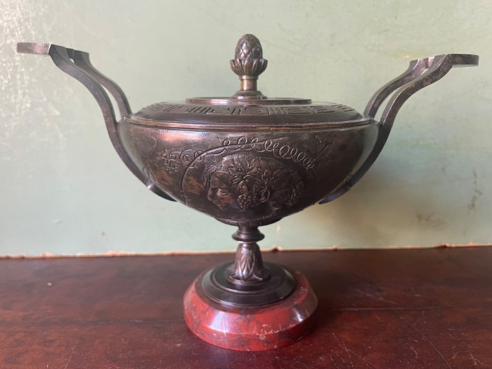 A nineteenth-century bronze lidded tazza featuring Greek key chasing and elevated handles, supported by a round red marble base. View II