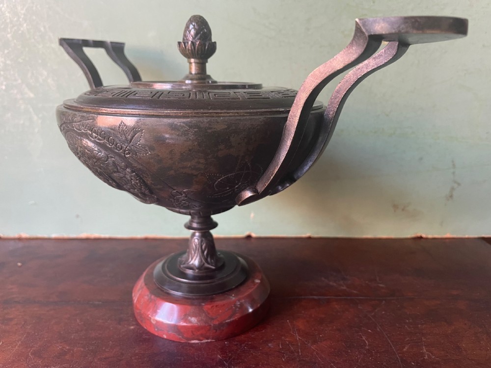 A nineteenth-century bronze lidded tazza featuring Greek key chasing and elevated handles, supported by a round red marble base. View III