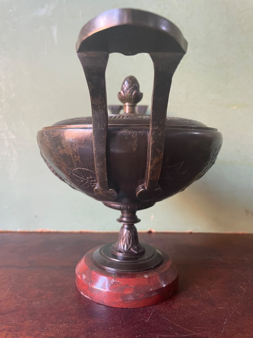 A nineteenth-century bronze lidded tazza featuring Greek key chasing and elevated handles, supported by a round red marble base. View V