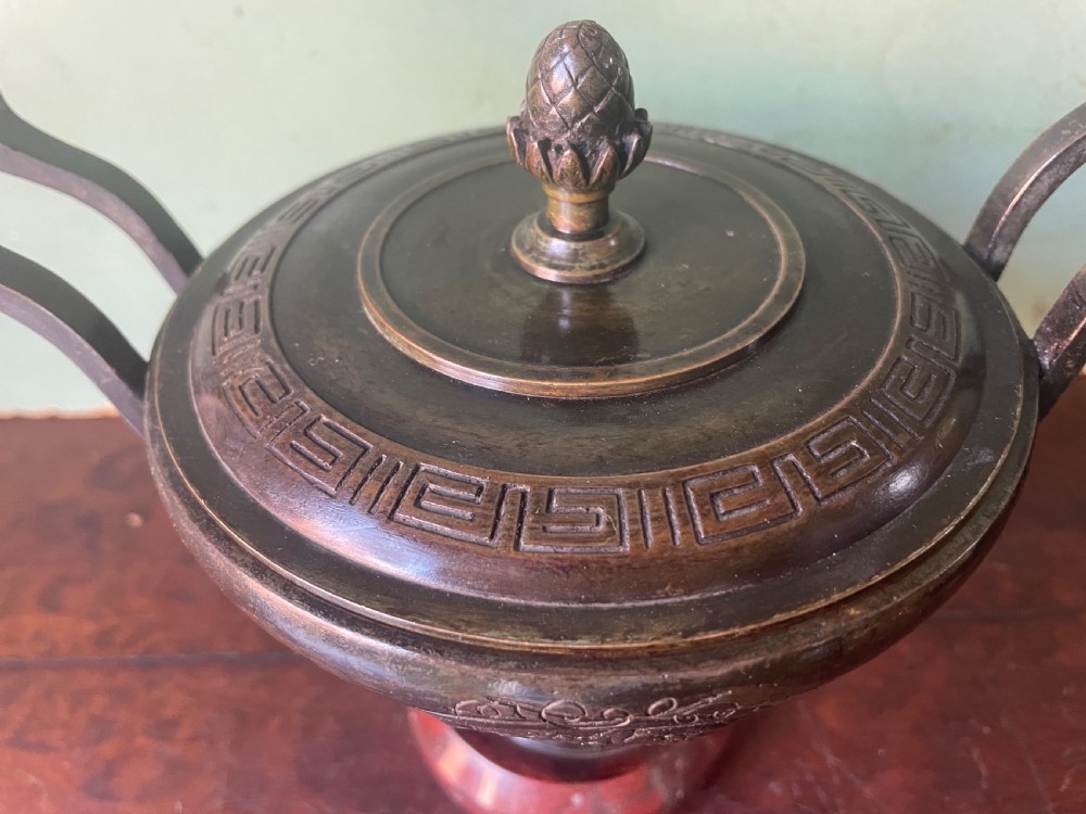 A nineteenth-century bronze lidded tazza featuring Greek key chasing and elevated handles, supported by a round red marble base. View VIII