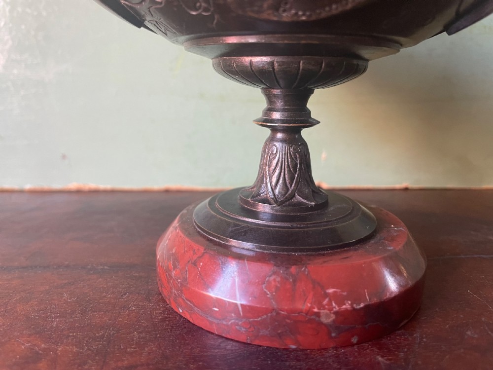 A nineteenth-century bronze lidded tazza featuring Greek key chasing and elevated handles, supported by a round red marble base. View XI