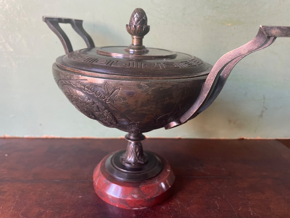 A nineteenth-century bronze lidded tazza featuring Greek key chasing and elevated handles, supported by a round red marble base. View XIII