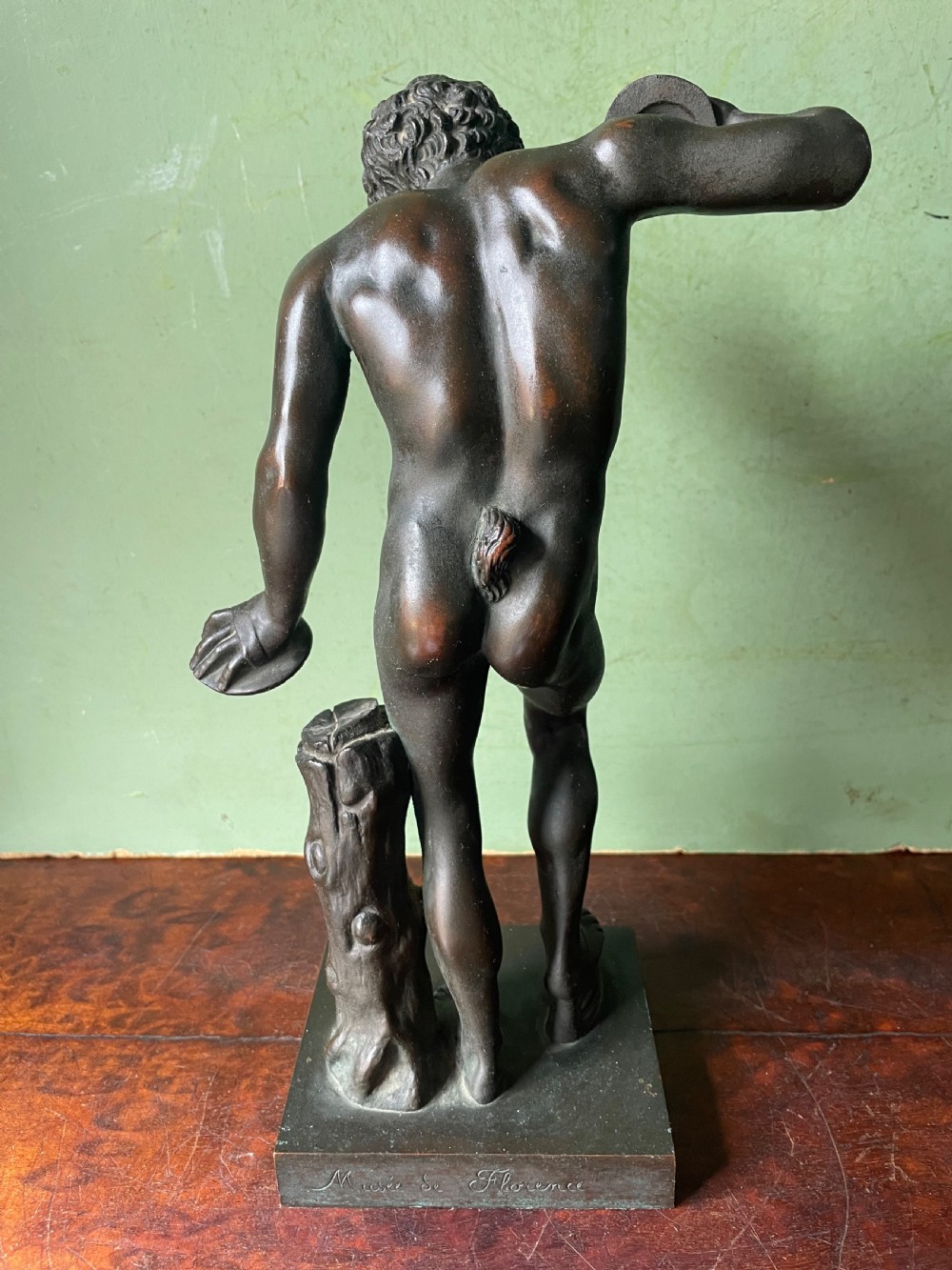 A dark patinated bronze sculpture depicting the classical figure of the Dancing Faun holding cymbals, mounted on a rectangular metal plinth. View VIII