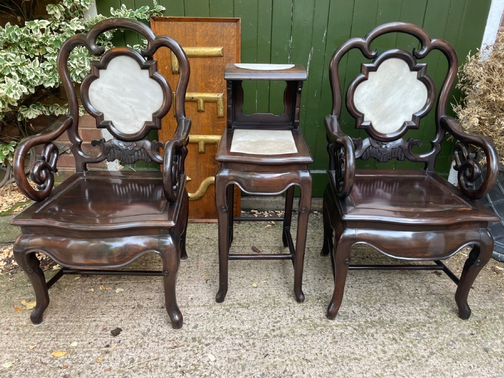A pair of late Qing Dynasty dark hardwood armchairs with circular marble splat inlays flanking a matching two-tier stand. View V
