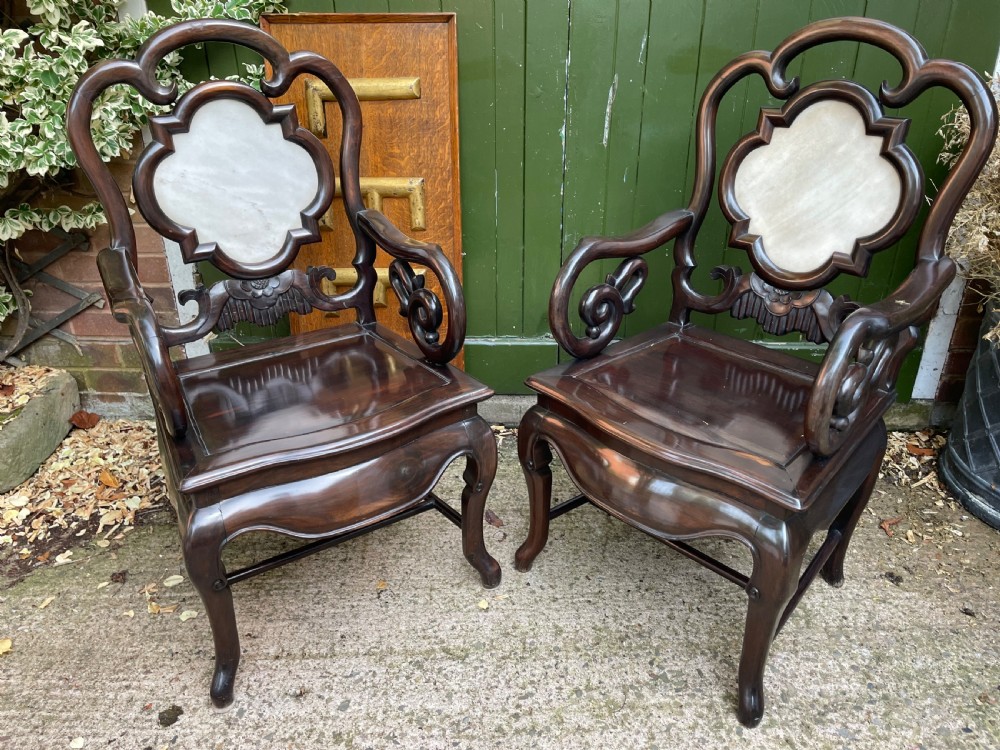 A pair of late Qing Dynasty dark hardwood armchairs with circular marble splat inlays flanking a matching two-tier stand. View VIII