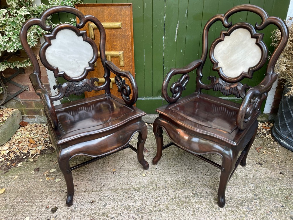 A pair of late Qing Dynasty dark hardwood armchairs with circular marble splat inlays flanking a matching two-tier stand. View XI