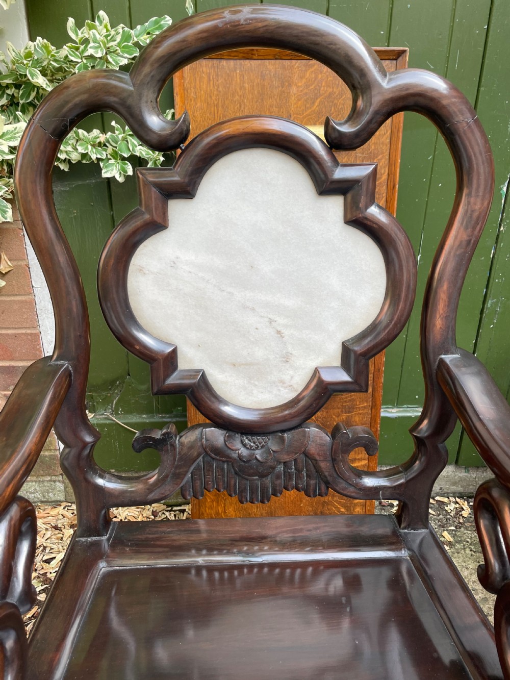 A pair of late Qing Dynasty dark hardwood armchairs with circular marble splat inlays flanking a matching two-tier stand. View XII