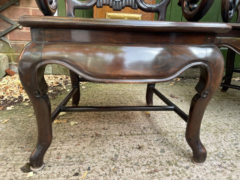 A pair of late Qing Dynasty dark hardwood armchairs with circular marble splat inlays flanking a matching two-tier stand. View XIII