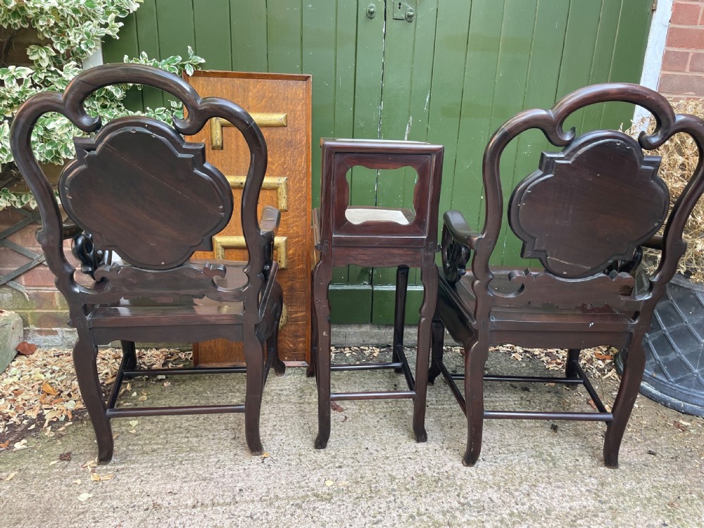 A pair of late Qing Dynasty dark hardwood armchairs with circular marble splat inlays flanking a matching two-tier stand. View XVII