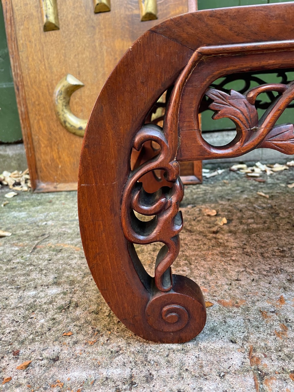 A low carved dark hardwood Chinese Kang table featuring scroll feet and a pierced floral apron. View II