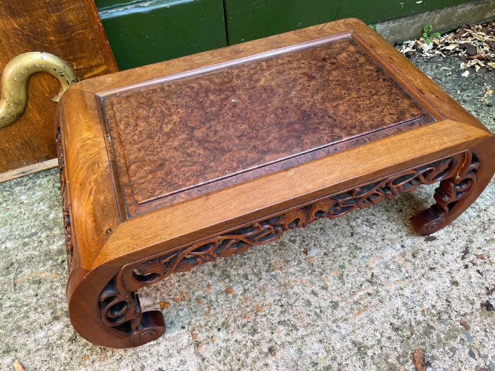 A low carved dark hardwood Chinese Kang table featuring scroll feet and a pierced floral apron. View V