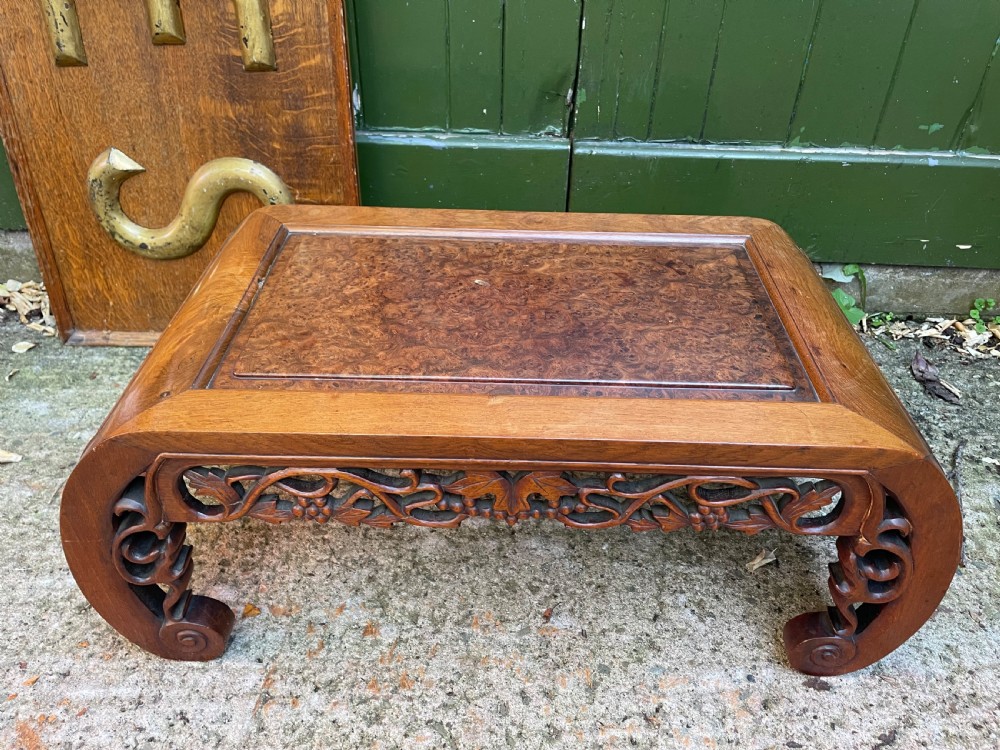 A low carved dark hardwood Chinese Kang table featuring scroll feet and a pierced floral apron. View IX