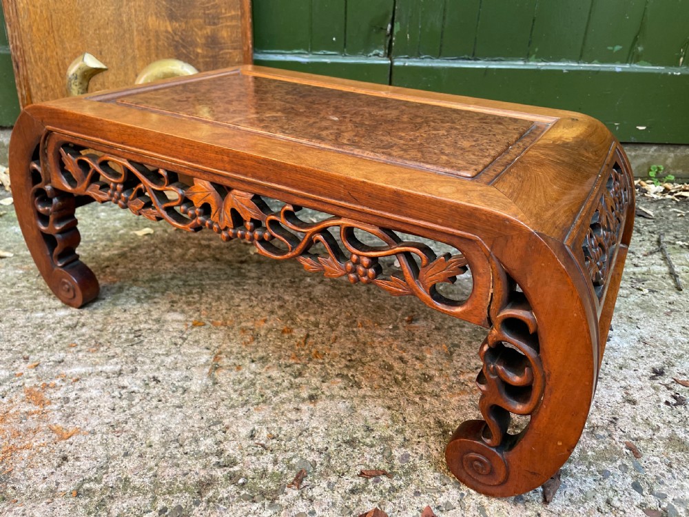 A low carved dark hardwood Chinese Kang table featuring scroll feet and a pierced floral apron. View X