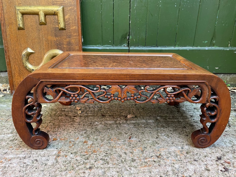 A low carved dark hardwood Chinese Kang table featuring scroll feet and a pierced floral apron. View XI