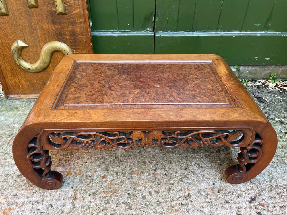A low carved dark hardwood Chinese Kang table featuring scroll feet and a pierced floral apron. View XII