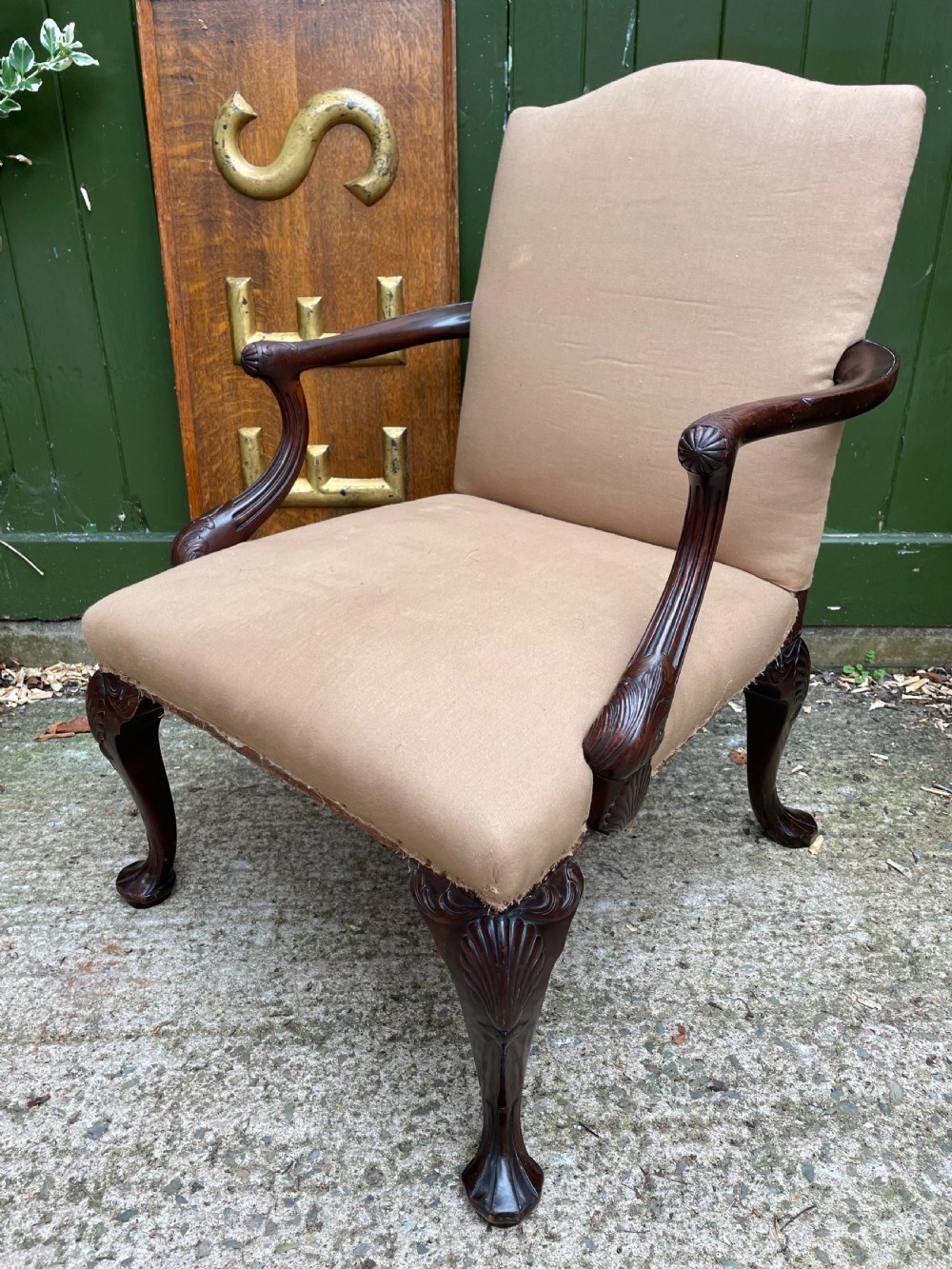 A mid-nineteenth-century carved mahogany Gainsborough armchair upholstered in neutral fabric with carved cabriole legs and claw and ball feet.