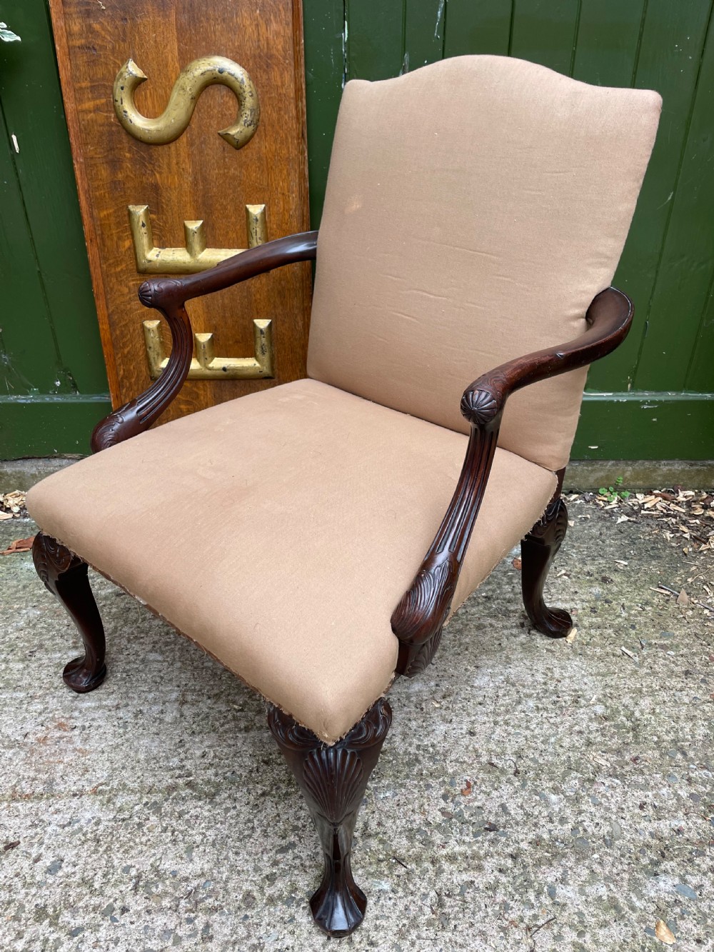 A mid-nineteenth-century carved mahogany Gainsborough armchair upholstered in neutral fabric with carved cabriole legs and claw and ball feet. View II