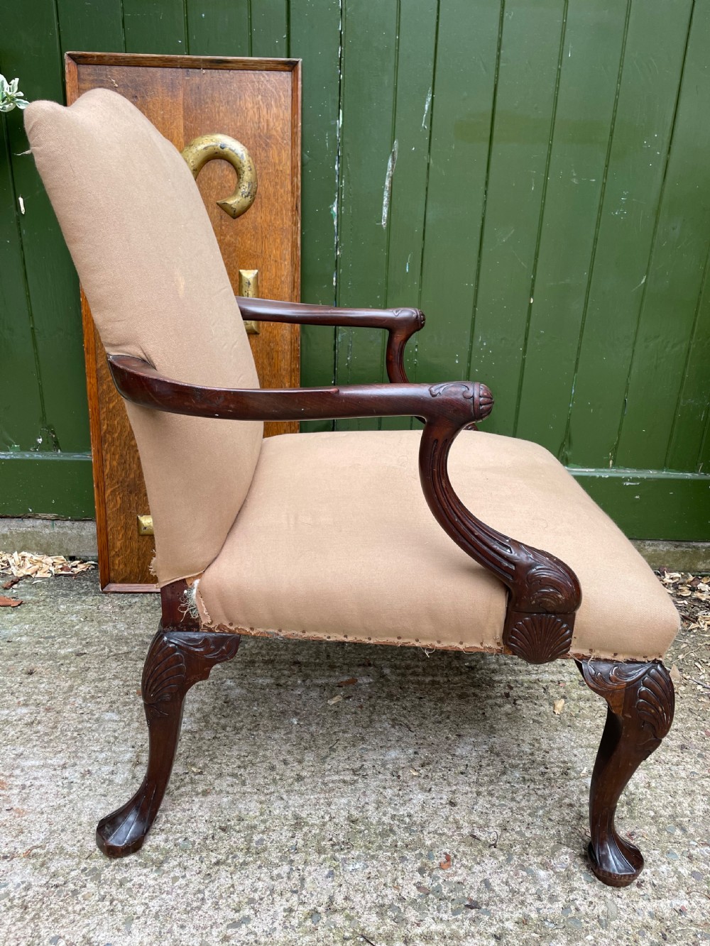 A mid-nineteenth-century carved mahogany Gainsborough armchair upholstered in neutral fabric with carved cabriole legs and claw and ball feet. View VI